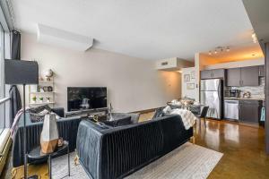 a living room with two couches and a kitchen at Jungle Book Luxe Suite Downtown BMO in Calgary