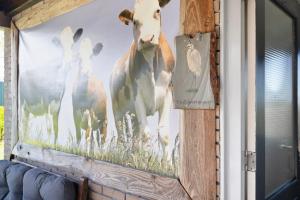 a painting of a cow on a wall at De Zilverreiger op camping Oudesluis in Oudesluis