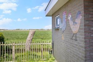 a mural of three chickens on the side of a building at De Zilverreiger op camping Oudesluis in Oudesluis