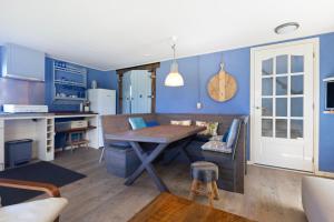 a kitchen with blue walls and a wooden table at De Zilverreiger op camping Oudesluis in Oudesluis +35 photos