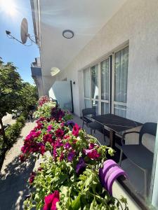a balcony with flowers and a table and chairs at Villa24 Vlore in Vlorë