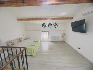 a living room with a bed and a tv at La Casa Rossa II in Verona