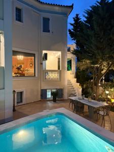 a villa with a swimming pool in front of a house at Chris Villa in Perdika