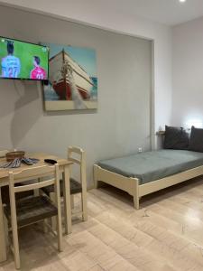a bedroom with a bed and a table and a tv at Argo Apartments in Kato Daratso