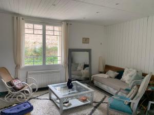 a living room with a couch and a table at Chez Chris in Jard-sur-Mer