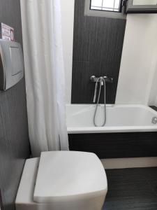 a bathroom with a white toilet and a bath tub at Sea & Summit Pool Villa in Platamonas +46 photos