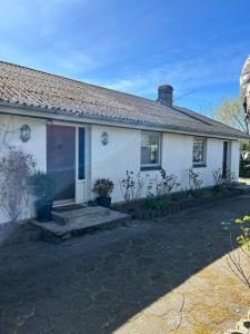 a white house with a window and a driveway at Risskov sommerhus in Risskov +8 photos