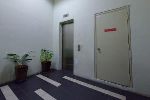 a hallway with a door and two potted plants at SMC Hotel Seksyen 13 in Shah Alam