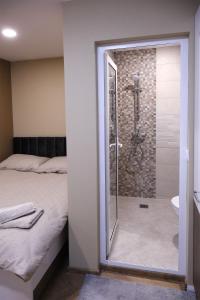 a bathroom with a shower and a bed with a glass door at BS Brother in Ruse +28 photos
