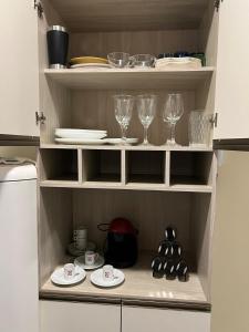 a cupboard with wine glasses and plates in it at Apartamento in Campo Largo