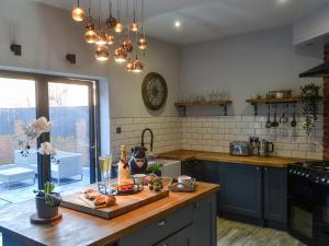 a kitchen with a cutting board with food on a counter at Copper Cottage in Morpeth