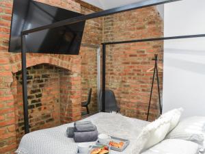 a room with a bed and a brick wall at Copper Cottage in Morpeth +5 photos