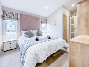 a bedroom with a large bed with a purple headboard at Turnberry Lodge in Girvan