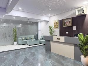 a lobby with a waiting room with blue couches at Shri Prem Sharnam - By The Aureo Hotels in Vrindāvan