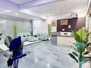 a waiting room with blue chairs and plants at Shri Prem Sharnam - By The Aureo Hotels in Vrindāvan