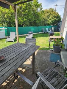 a wooden picnic table and chairs in a backyard at Charmante maison in Dinard +8 photos