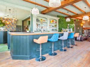 a kitchen with a blue bar with stools at Alderfalls - Exclusive Private Pub Experience in Coelbren