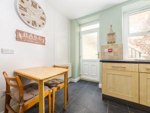 a kitchen with a table and a clock on the wall at The Garden Apartment in Peel