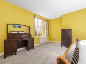 a bedroom with a dresser and a mirror at The Garden Apartment in Peel