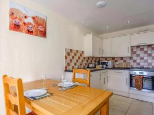 a kitchen with a wooden table with two plates on it at Cut Lloi in Llanfair Caereinion