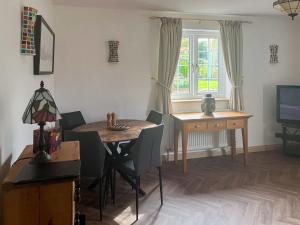 a dining room with a table and chairs and a window at The Cottage in Castle Hedingham
