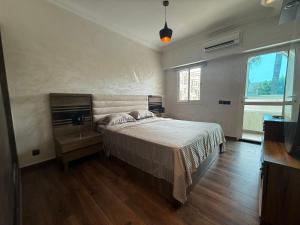 a bedroom with a bed and a large window at Pavillon corniche Bord de mer Proche Centre in Mohammedia