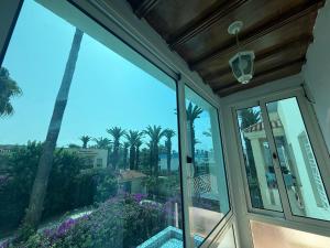 a room with a view of the palm trees at Pavillon corniche Bord de mer Proche Centre in Mohammedia