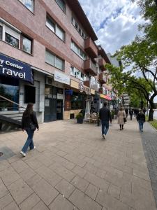people walking down a sidewalk in front of a building at Boulevard Studios NewBorn in Prishtinë