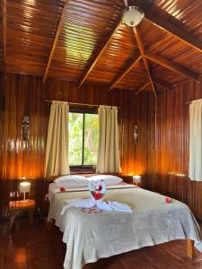 a bedroom with a large bed with wooden walls at Hotel El Jardin in Montezuma