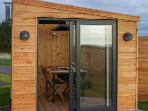 an outside view of a wooden shed with a table at Ben Aigan - Ukc6027 in Newmill