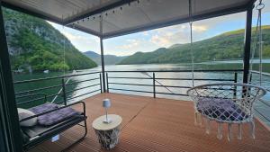 a balcony with a swing and a chair on a boat at Splav Rio in Aluga