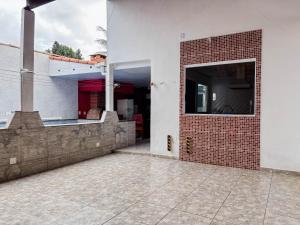 an open door of a house with a brick wall at Casa Sossego Com Piscina Aquecida, Hidro e Cascata in Peruíbe