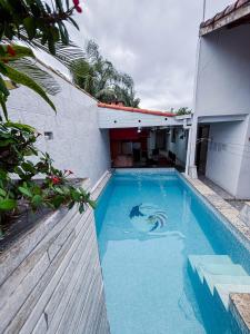 a blue swimming pool in the side of a building at Casa Sossego Com Piscina Aquecida, Hidro e Cascata in Peruíbe