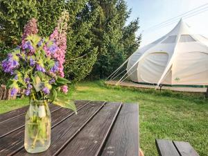 a vase of flowers on a wooden table with a tent at Shepherds Belle & Croft Hut - Qu7633 in Messing