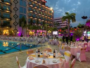 a banquet area with tables and chairs and a pool at Atlantic Palace Hotel in Pointe-Noire