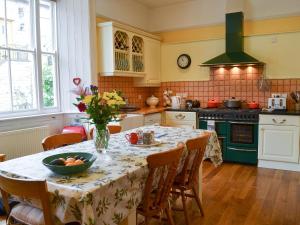 a kitchen with a table with a vase of flowers on it at The Old King's Head Pickering in Pickering