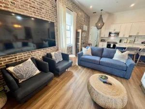 a living room with blue couches and a brick wall at Harbor House Penthouse- B in Key West