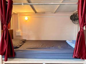 a bed in a room with red curtains at 5 Star Yatri Vishram AC & Non AC Dormitory in Jabalpur
