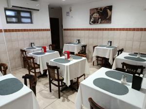 a restaurant with white tables and chairs with red napkins at Hotel Natal in Santos