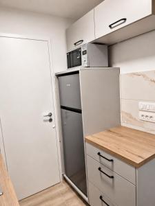 a small kitchen with a refrigerator and a microwave at Apartment Nero in Izola