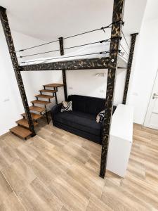 a living room with a black couch and stairs at Apartment Nero in Izola