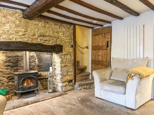 a living room with a chair and a fireplace at Hailey Cottage in Chipping Norton