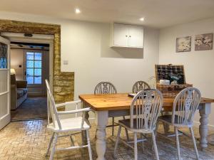 a kitchen and dining room with a wooden table and chairs at Hailey Cottage in Chipping Norton
