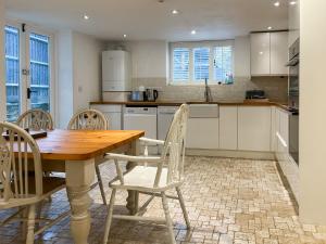 a kitchen with a wooden table and chairs at Hailey Cottage in Chipping Norton