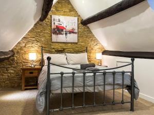 a bedroom with a bed in a stone wall at Hailey Cottage in Chipping Norton +6 photos