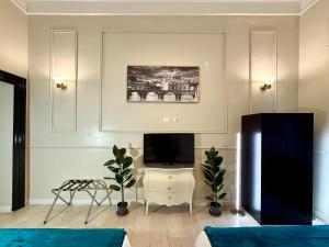 a living room with a tv and a tv stand with a television at Spanish Steps Boutique Hotel - Madame Sofia Secret Hotel in Rome