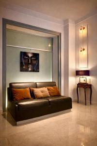 a leather couch in a living room with a picture at Spanish Steps Boutique Hotel - Madame Sofia Secret Hotel in Rome