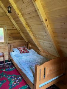 a bed in the attic of a log cabin at Kamp-Seosko Domaćinstvo Dizdarević in Bijelo Polje