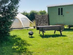 a picnic table and a grill in a yard with a tent at Shepherds Belle & Croft Hut - Qu7633 in Messing