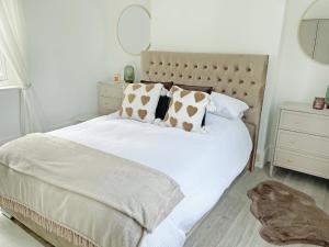 a bedroom with a white bed with brown pillows at Joss Bay Days in Broadstairs